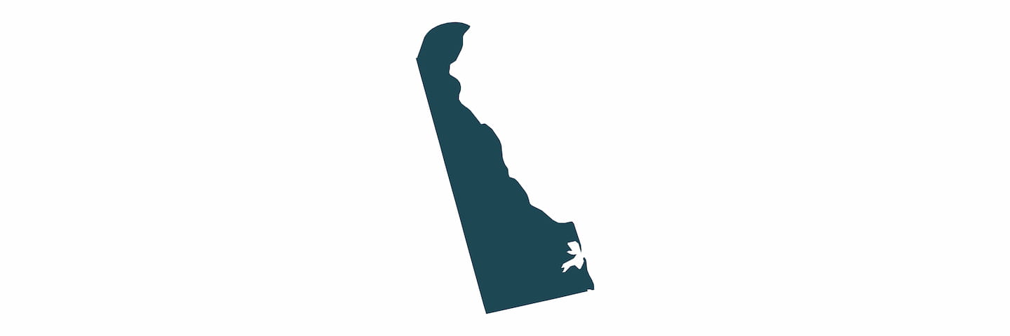 A simplified, dark blue silhouette map of Delaware on a light background, featuring a distinct outline with the northern border curving slightly.